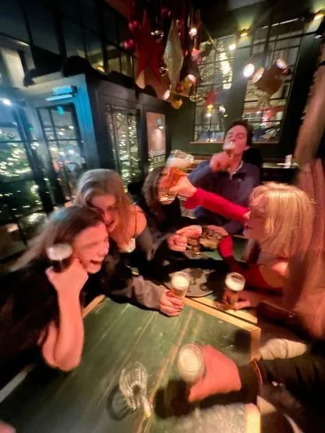 Friends sharing drinks at a table in a lively neighborhood bar